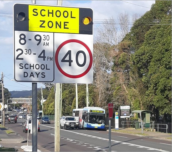 Back to school speed sign with road and bus in background