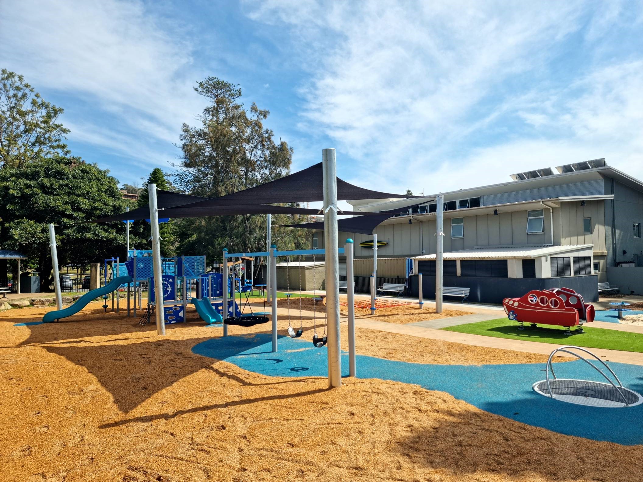 new play equipment with sun shelter, swings, seating, slides