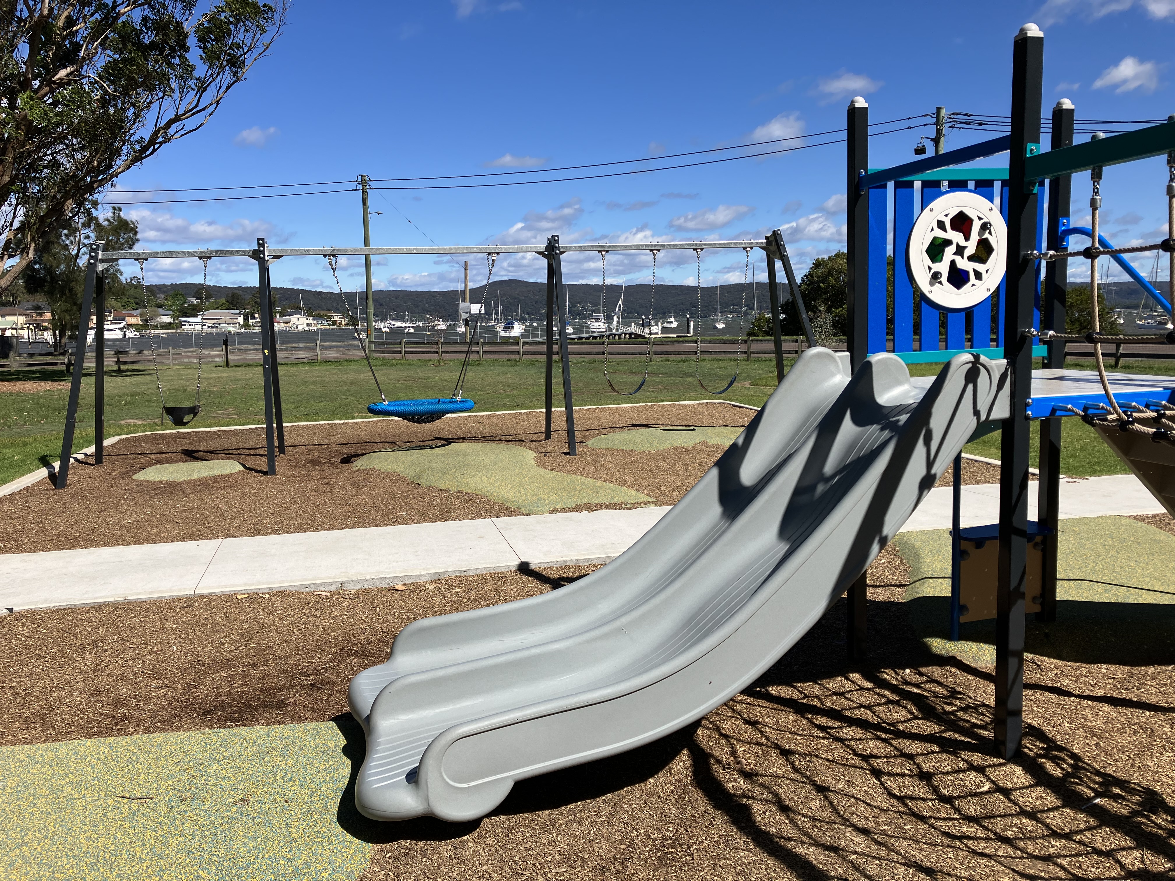 slide and swings with water in background 