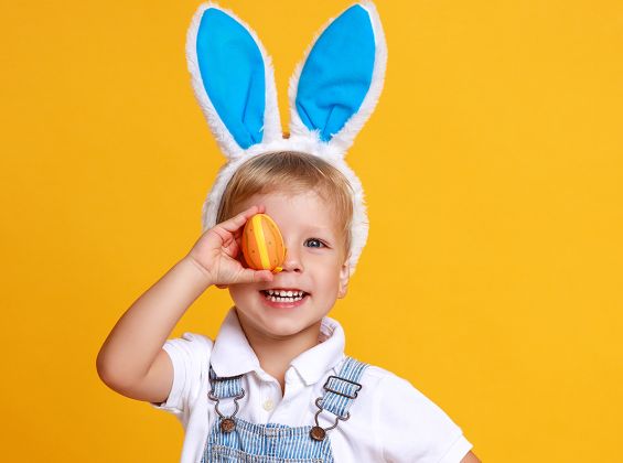 Child holding easter egg and wearing bunny ears