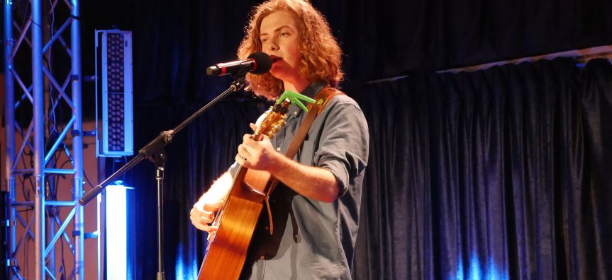 singer/songwriter Riley Puffle performing with acoustic guitar