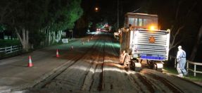 heavy machinery and worker on road at night